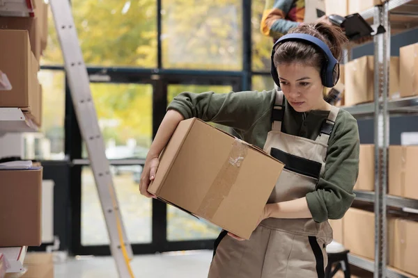 Depo Çalışanı Depoda Çalışırken Karton Kutu Taşıyıp Listeyi Analiz Ediyor — Stok fotoğraf