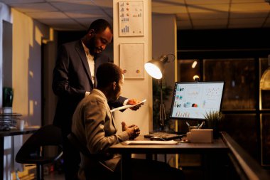 Finansal grafikleri analiz eden şirket çalışanları şirket stratejisini gece geç saatlerde yeni açılan ofiste tartıştıklarını rapor ettiler. Yatırım planında çalışan yönetici yöneticiler ticari karı artırmak için çalışıyorlar