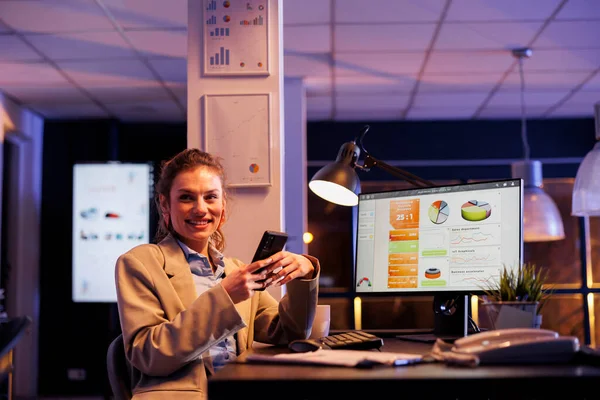 Uśmiechnięta Bizneswoman Trzymająca Telefon Przeglądająca Aplikację Mediach Społecznościowych Pracująca Godzinach — Zdjęcie stockowe