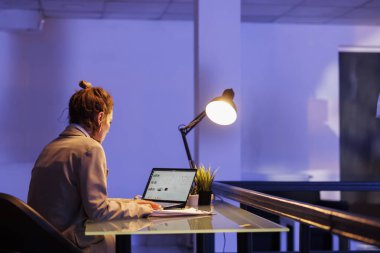 Girişimci finansal büyüme raporunu analiz ediyor, şirket stratejisinde yeni açılan ofiste fazla mesai yapıyor. Yönetici masasında oturmuş, kazancı artırmak için yatırım planını düşünüyor..