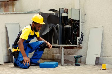Önde gelen mühendis, açık hava klimasının yıllık bakımına başlıyor, alet kutusunu hazırlıyor. Tecrübeli tamirci hasarlı hvac sistem iç bileşenlerini kontrol etmek için aletleri hazırlıyor