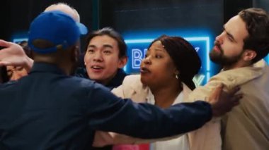 Endişeli insanlar anlaşmalar için sırada bekliyor, giyim mağazasının girişinde bürokrasinin arkasında bekliyorlar. Çılgın kalabalık, Kara Cuma indirimleri için bariyer zorluyor, agresif müşteriler. El kamerasıyla..