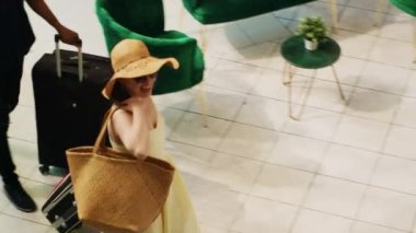 Otelin resepsiyonuna gelen turistler resepsiyona kayıt yaptırmaya ve odaya girmeye hazırlanıyorlar. Balayı tropik tatilinde seyahat eden misafirler otel lobisinde çalışanlarla konuşuyor. El kamerasıyla..