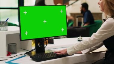 Girişteki lobide yeşil ekran bilgisayar kullanan resepsiyonist, krom anahtar şablonu ile izole ekrana bakıyor. Otelin resepsiyondaki kapıcısı bilgisayardaki kopyalama alanını kontrol ediyor.