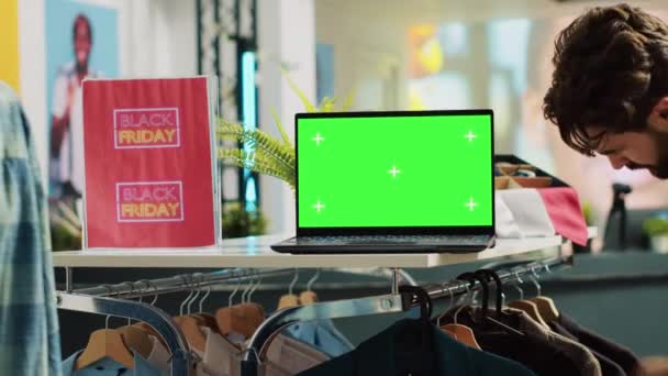 黑色星期五 绿色屏幕在商店里 人们浏览衣架 供季节性销售用的购物中心 笔记本电脑上有独立的铬钥匙显示屏 版权空间 — 图库视频影像