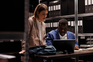 Muhasebe raporlarını analiz eden çeşitli muhasebeciler, kurumsal depodaki idari belgeleri kontrol ediyorlar. Depo çalışanları gece geç saatlere kadar bürokrasi kayıtlarını okuyorlar.