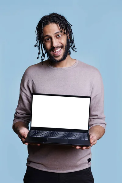 兴高采烈的阿拉伯男子站在笔记本电脑前 用空白屏幕显示网页上的肖像 拿着白色显示屏的手提电脑做广告和看相机的人 — 图库照片