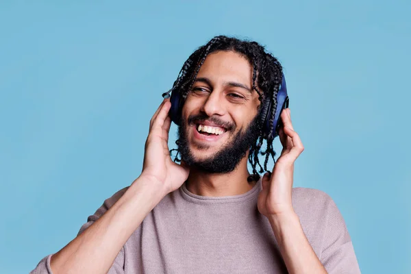 Безтурботний Арабський Чоловік Слухає Плейлист Пісень Бездротових Навушниках Посміхаючись Дивлячись — стокове фото