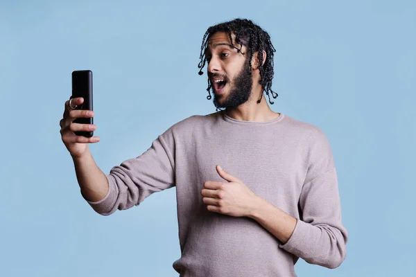 阿拉伯男子在视频通话中使用智能手机前置摄像头 年轻人在视频会议会议应用中一边说一边拿着手机一边进行在线交流 — 图库照片