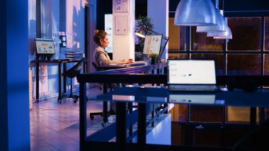 Şirket ofisinde online istatistikleri inceleyen, geceleri pazarlama geliştirmeyi planlayan mutlu girişimci. Resmi rapor oluşturmak için ekonomi diyagramlarına bakan genç yetişkinler. El kamerasıyla..