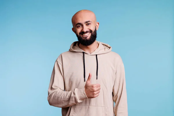 用大拇指对着阿拉伯男子笑 表示认可 并看着相机 快乐的年轻人 有着无忧无虑的面部表情 摆出满意的姿势和同意的姿势 — 图库照片