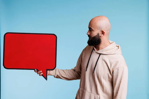 阿拉伯男子广告产品与空的红色横幅 显示文字框架 持空白对话泡状带应对空间的年轻人模拟促销信息 — 图库照片