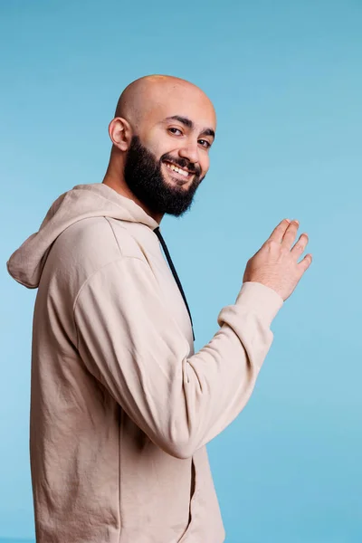 Uśmiechnięty Arabczyk Zapraszający Gestem Ramienia Patrzący Kamerę Wesołym Wyrazem Twarzy — Zdjęcie stockowe