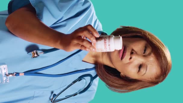 Vrolijke Bekwame Verpleegkundige Die Cardiovasculaire Flessenpil Het Aanbieden Van Medische — Stockvideo