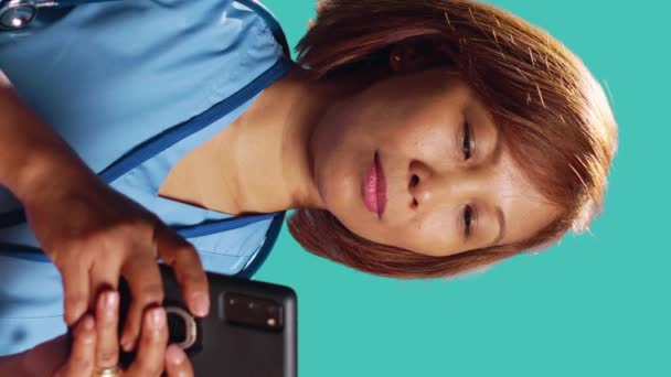 Zbliżenie Wesołego Pracownika Kliniki Smsującego Przez Telefon Podczas Pracy Cieszącego — Wideo stockowe