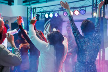 İnsanlar dans pistinde elektronik müzik ritmine geçerken parti yapıp el kaldırıyorlar. Gece kulübünde DJ 'lik yaparken çeşitli arkadaşlar dans ediyor ve gece hayatı aktivitelerinden zevk alıyorlar.