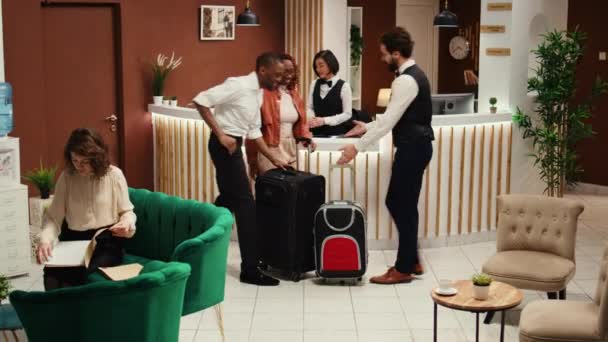 Zrelaksowana Afrykańska Para Daje Napiwki Przyjaznemu Pracownikowi Hotelowego Boya Pomagając — Wideo stockowe