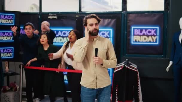 ブラック フライデーに生中継される混雑した店内のテレビ記者は 現場でマイクでニュース放送を制作しています 季節割引の開始衣料品店のオーナー — ストック動画