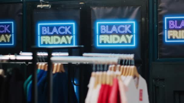 空のファッションデパートで販売と割引アイテム 小売店で服をハンガー 11月の季節のプロモーションの間に黒い金曜日の広告 特別オファーサイン — ストック動画