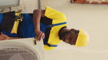 Dikey video ekibi çeşitli uzmanları hasarlı Hvac sistemi üzerinde çalışmaya başlıyor, yoğunlaştırıcı bobin panelini ayırıyorlar. Yetenekli teller kötü elektrik tesisatını kontrol etmek için havalandırmayı söküyor.
