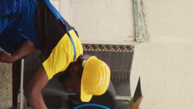 HVAC sistem temizliği için görevlendirilen dikey video uzmanları, tıkanmış hava filtresini temizlemek, hava akışını kısıtlamak, verimliliği azaltmak ve soğutma birimini soğutmak için toz fırçası kullanılıyor