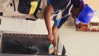 Geleneksel klima bakımı için müşteri tarafından sipariş edilen dikey video sertifikalı teknisyen, tozlu yoğunlaştırıcı bobinleri ve filtreleri temizlemek için yumuşak toz fırçası kullanıyor, açık hava