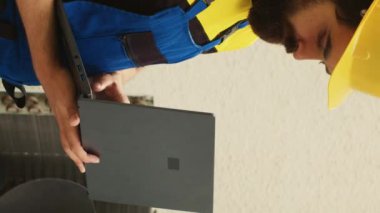 Yeni kondansatör için dizüstü bilgisayar kullanan dikey video uzmanı, açık hava klimasının bakım sırasında arızalı iç bileşenini buldu.