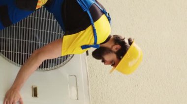 Dikey video teknisyeni bozuk havalandırmayı tamir etmek için kontrat yaptı. Bozuk havalandırma vantilatörünü kontrol etmek için kondansatör ön bobin panelini söktü. Hatalı kabloları kontrol etmek için Wireman HVC sistemi açıyor
