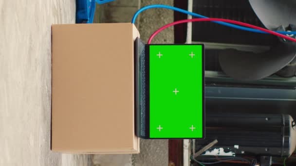 垂直ビデオエアコンの外にサービスの前に緑の画面のラップトップ 専門家のメンテナンスを必要とする損傷した外部Hvacシステムの隣にクロマキーガジェットのディスプレイをモックアップ — ストック動画