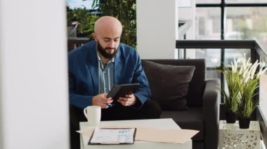 Ortadoğulu adam tablet hakkında notlar alıyor ve kâr etmek için yeni yatırım stratejileri yaratıyor. Yapay zeka geliştiricisi programlama analizleri üzerinde çalışır, küçük işletme ofisinde sunucu betiği okur.