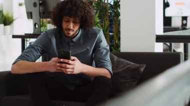 Başlangıç yöneticisi modern açık uzay ofisinde telefonla çalışıyor. Şirket danışmanı, internet istatistiklerini yönetiyor. Küçük işletmelerin gelişmesine ve kârın artmasına yardımcı oluyor. Akıllı telefon uygulaması. El kamerasıyla..