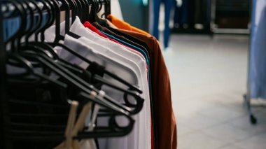 Giyim mağazasında asılı birden fazla resmi ya da günlük kıyafet, modaya uygun ürün ve ürünlerle dolu emoty alışveriş merkezi butiği. Moda küçük işletme konsepti. Kapat..