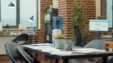 Ortak çalışma alanında veri dosyaları olan boş iş bürosu, küresel kalkınma için kullanılan belgelerle ilgili resmi raporlarla dolu sandık masaları. İstatistik ve analizli şirket çalışma istasyonları.