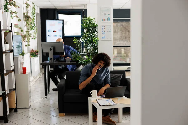 厌倦了Arab公司的员工在新成立的办公室工作的同时 在笔记本电脑上解决复杂的业务任务 坐在沙发上分析市场调研的牙疼执行经理 — 图库照片
