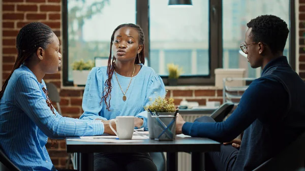 アフリカ系アメリカ人チームは 企業会議でアイデアを話し合い ビジネス開発のための新しい解決策を見つける スタートアップのコワーキングスペースでレポートコラボレーションを行う従業員チーム 三脚ショット — ストック写真