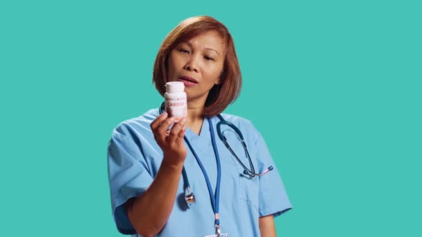 Enthousiaste Infirmière Qualifiée Tenant Pilule Bouteille Cardiovasculaire Offrant Des Conseils — Video