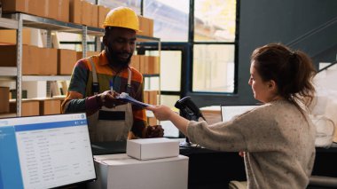 Personel ekibi malzeme listesini kontrol ediyor, sipariş teslimatı ve sevkiyat için lojistiği gözden geçiriyor. Küçük işletme dağılımı için hisse senedi envanterine bakan çeşitli insanlar..