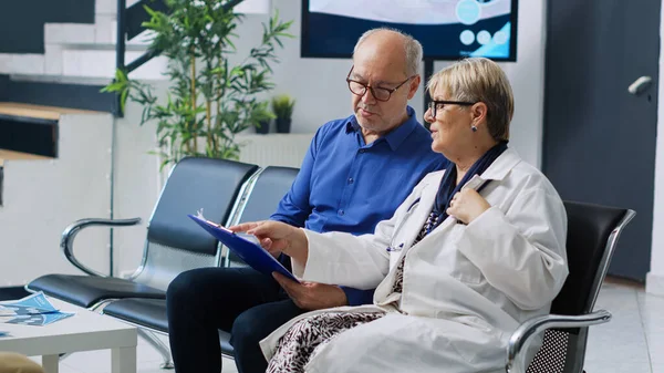 Medic Sitting Chair Hospital Lobby Explaining Disease Diagnosis Elderly Patient — Stock Photo, Image