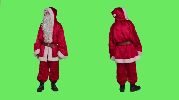 父のクリスマスは帽子と冬のキャラクターの衣装を身に着けて 脇に何かを押すふりをします サンタは拒絶として物体を押し進め 緑の画面の上で横にあるものを却下する — ストック動画