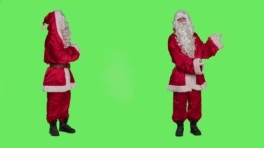 Noel Baba, Noel arifesi pazarlama ve yeşil ekran stüdyosu için kamera önünde reklam yapıyor. Aziz Nick 'in vücut bulmuş hali bir şey göstermek için sağı ve solu işaret ediyor. Kış kutlaması konsepti..