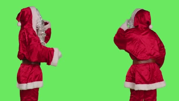 サンタコスプレは スタジオで緑の背景に甘いジェスチャーを行う カメラで空気のキスを与えます 若いです大人で赤い衣装演技浮気とロマンチックなとともに誰か クリスマスEve — ストック動画