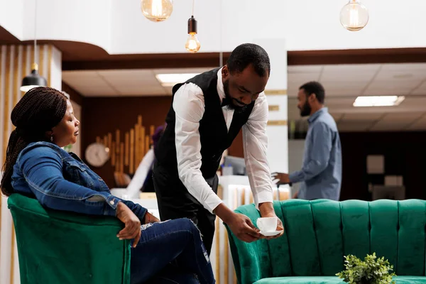 African American Guy Waiter Bringing Coffee Guest Resting Hotel Bar — Stock Photo, Image