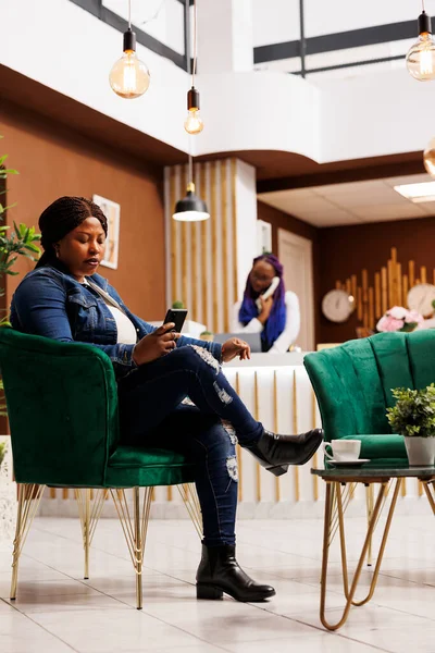 Afroamerykanka Turystka Siedzi Hotelowym Lobby Pomocą Smartfona Podłączając Wifi Kobieta — Zdjęcie stockowe