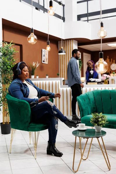 Relaxed African American Woman Hotel Guest Sitting Lobby Listening Music — Stock Photo, Image