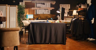 Alet ve eskizlerle dolu boş bir atölye, terzilik ekipmanları ve modern kumaşlı lüks el sanatları hizmetleri. İş istasyonları ve enstrümanları olan terzi atölyesi, küçük işletme.