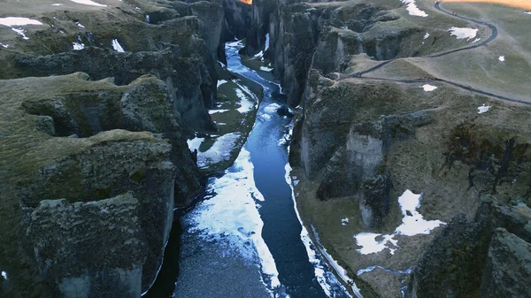 水の流れとアイスランドの風景 雪の山や巨大な岩と壮大なフィヨルドの氷河の峡谷の空中ビュー 丘の間を流れる川と雄大な北欧の風景 スローモーション — ストック写真