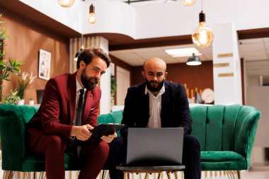 Otel resepsiyonu, dinamik bir ortaklığın başlangıç noktasını temsil eden iş gezisine ev sahipliği yapıyor. İki şirket çalışanı fikir alışverişinde bulunuyor ve önlerinde uzanan yeni fırsatları keşfediyorlar..