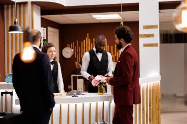 Otel personeli tarafından karşılanan profesyoneller, takım elbiseli işadamları lüks otellere geliyor. İş ortaklığı için seyahat eden, resepsiyonda kontrol yapan insanlar..