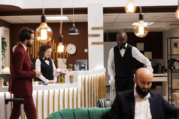 Goniec Hotelowy Pomaga Biznesmenowi Zameldowaniu Świadczy Usługi Konsjerża Luksusowym Holu — Zdjęcie stockowe