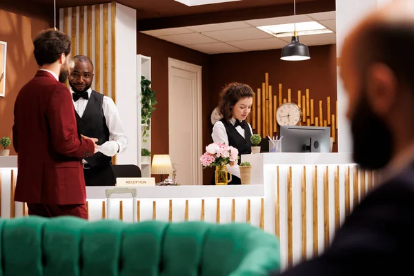 Otel Personeli Adamını Lobide Karşılıyor Kusursuz Verimli Bir Denetim Sağlıyor — Stok fotoğraf